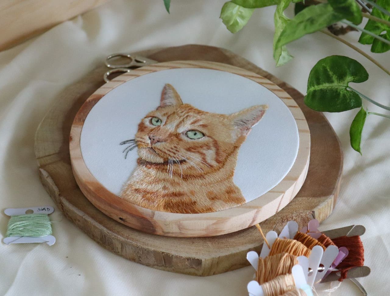 Mains brodant sur un cerceau de bois dans l'atelier Memoar